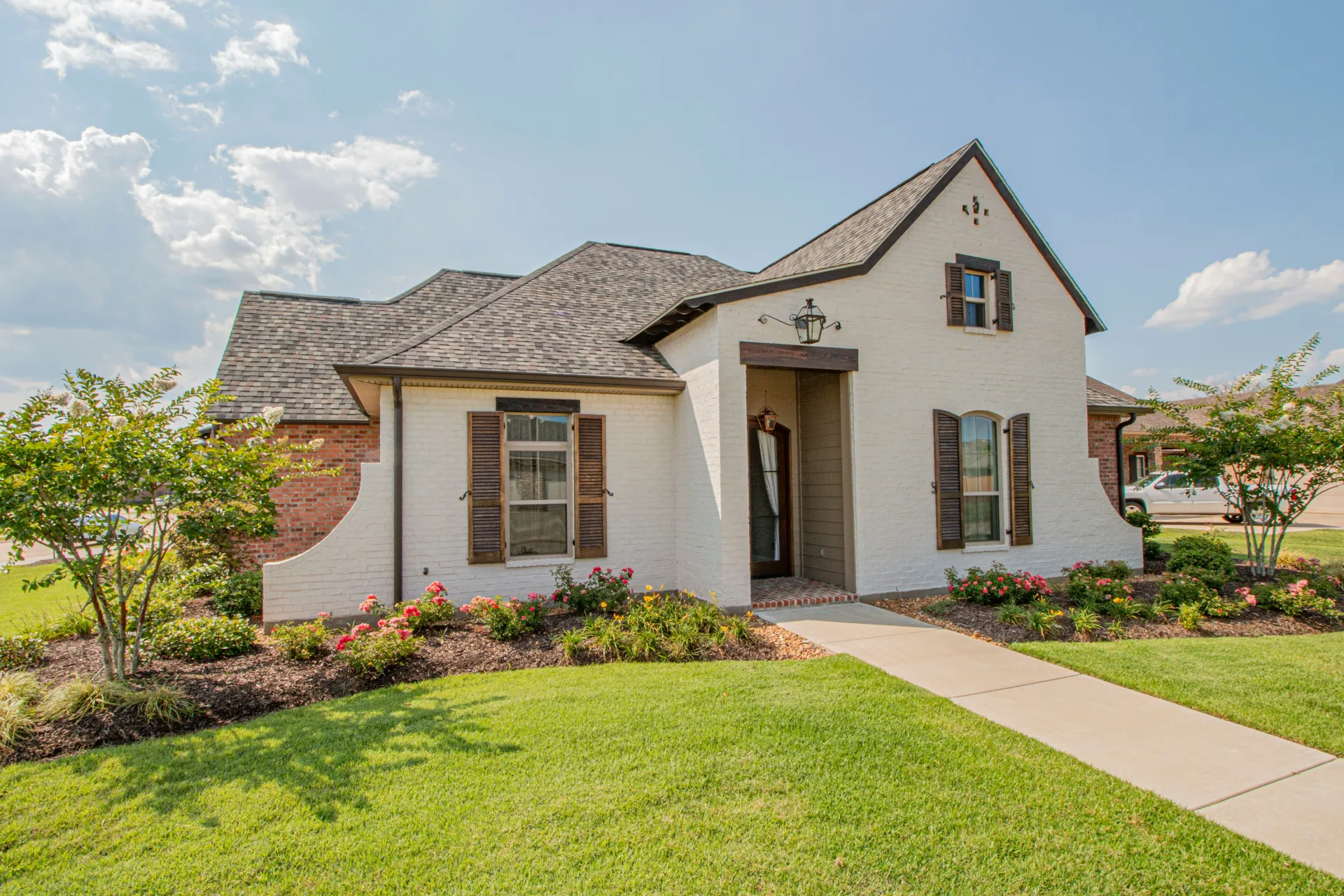 White brick cottage with landscaped front yard